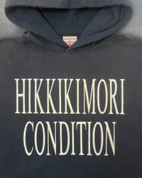 Detail view of slogan on HIKIKKOMORI CONDITION — Hoodie | Heavyweight French Terry in faded black