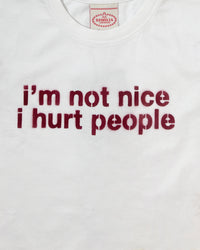 Detail view of slogan on I'M NOT NICE I HURT PEOPLE — Baby Tee in vintage white